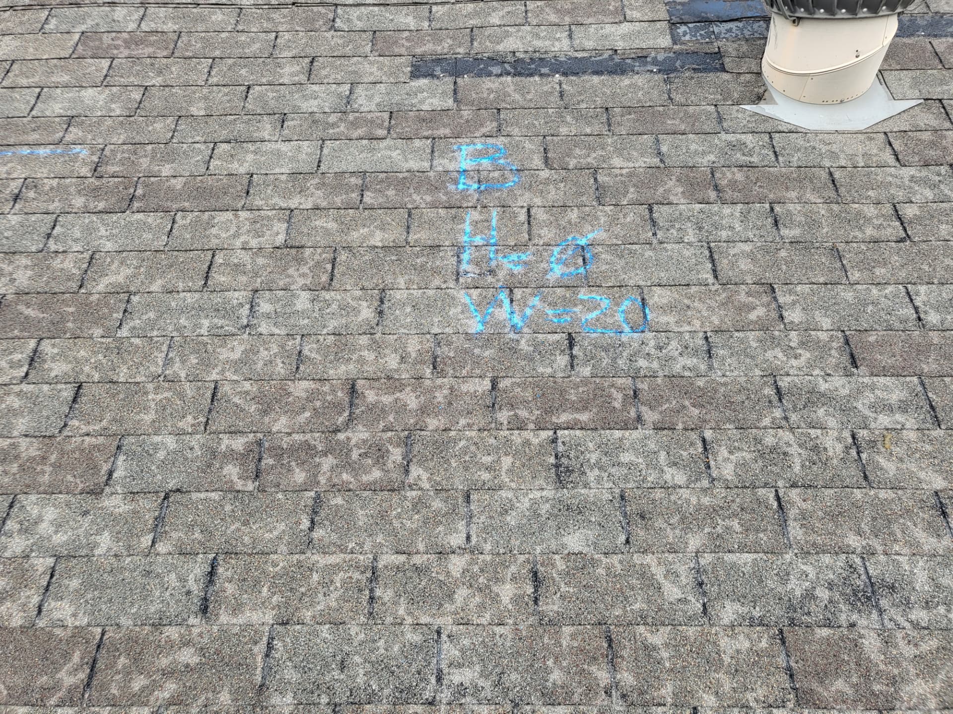 Weathered asphalt shingles with inspector chalk markings and a turbine vent on a Johnson County roof