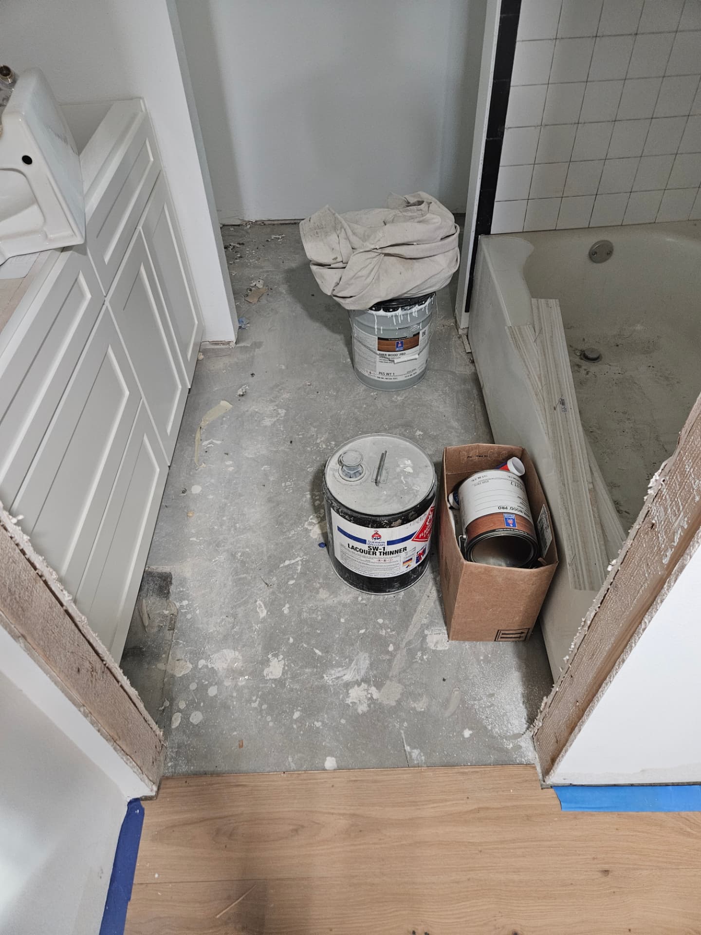 Johnson County bathroom mid remodel with worn tile and a tired tub surround