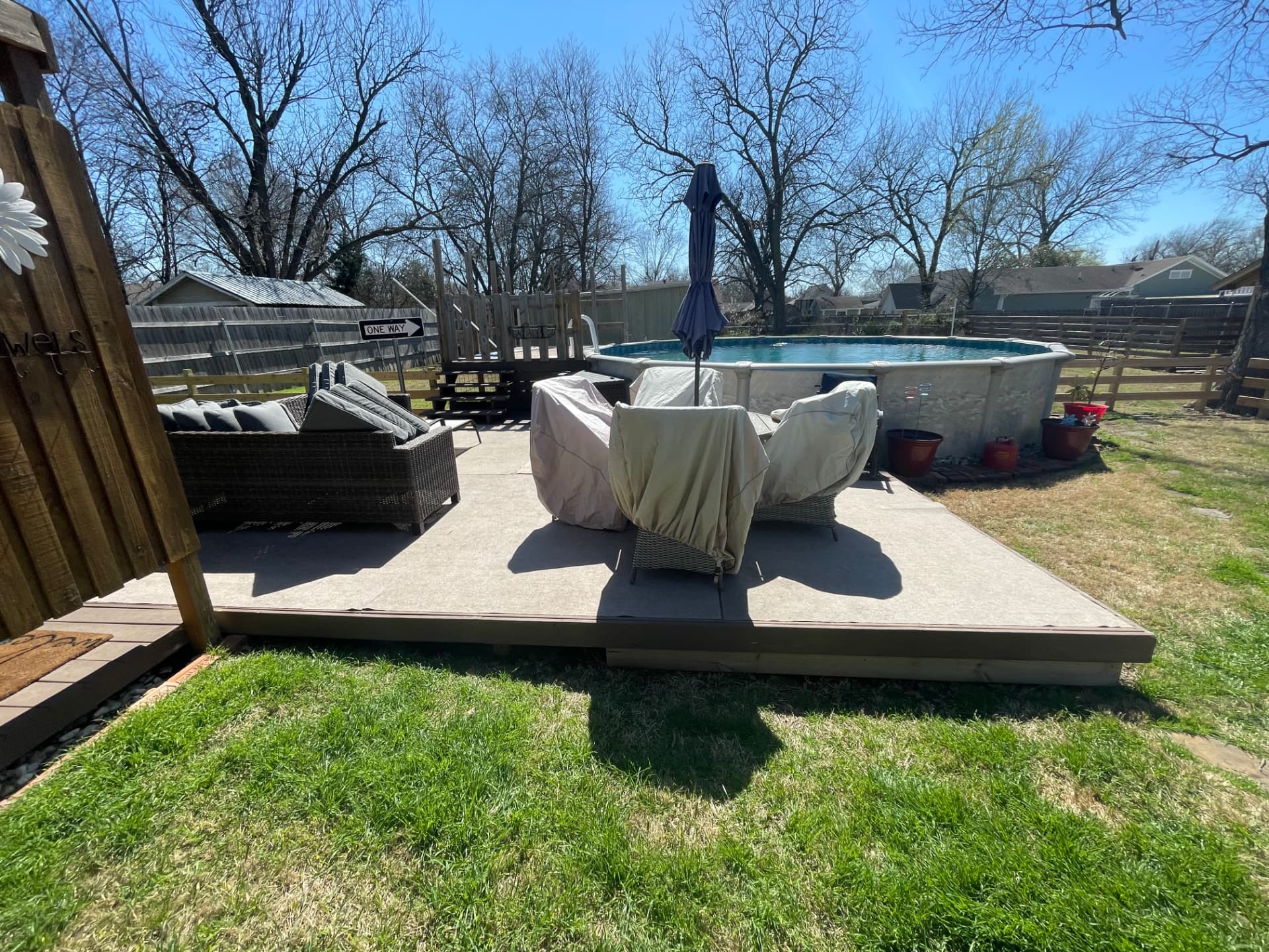 Finished backyard patio and raised deck with steps leading to an above-ground pool in a Johnson County backyard