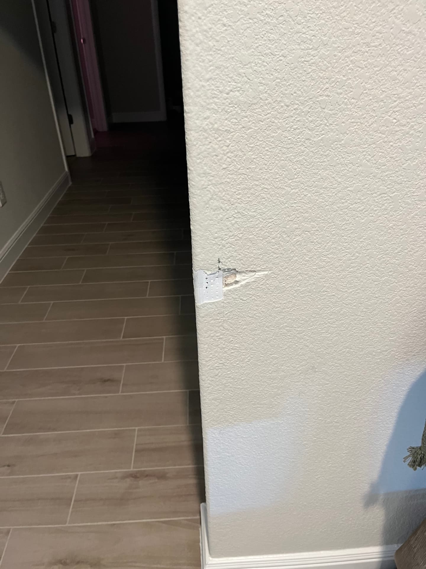 Cracked and peeling drywall corner on a textured wall in a Johnson County home