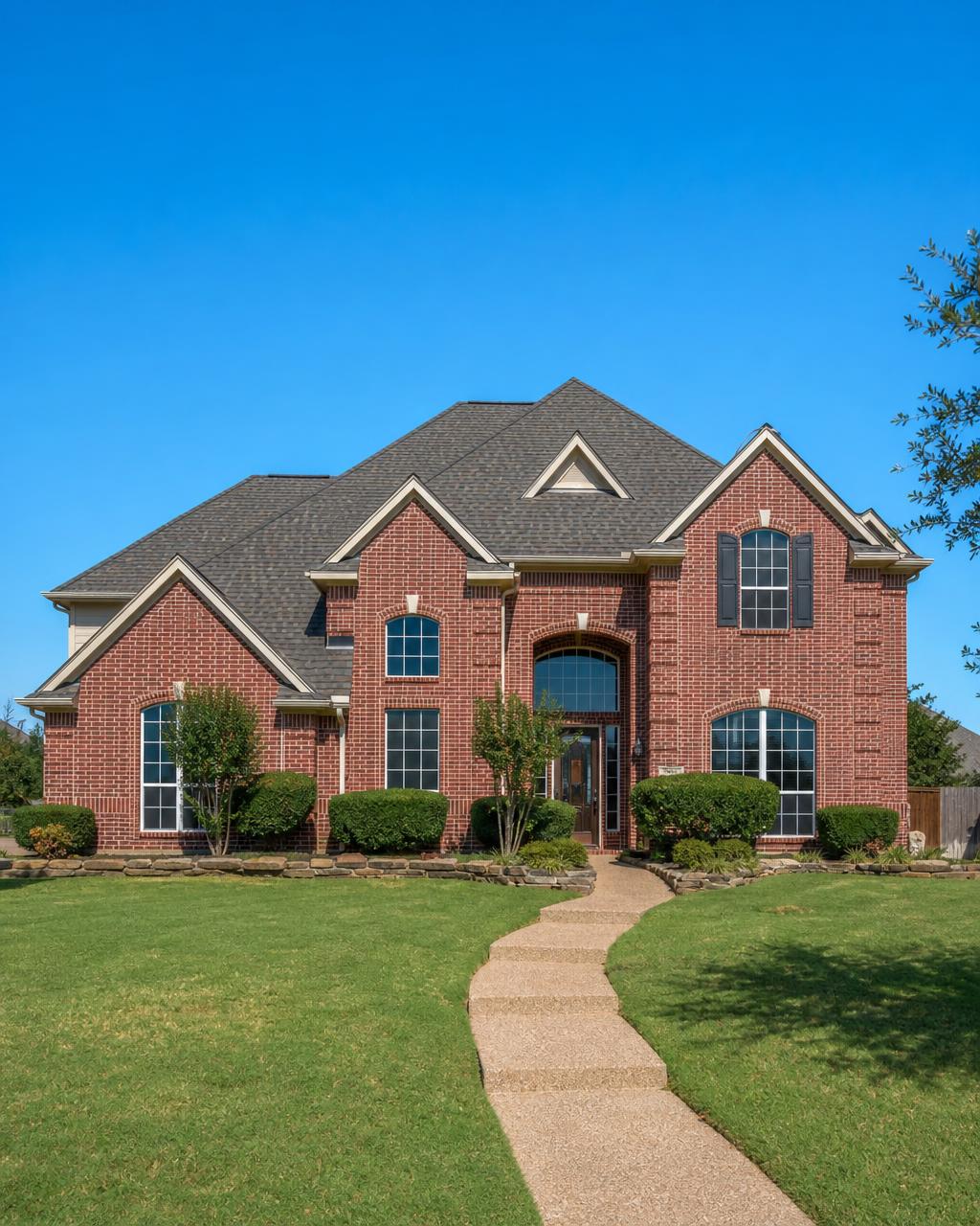Completed architectural shingle roof on a brick home in Burleson, TX