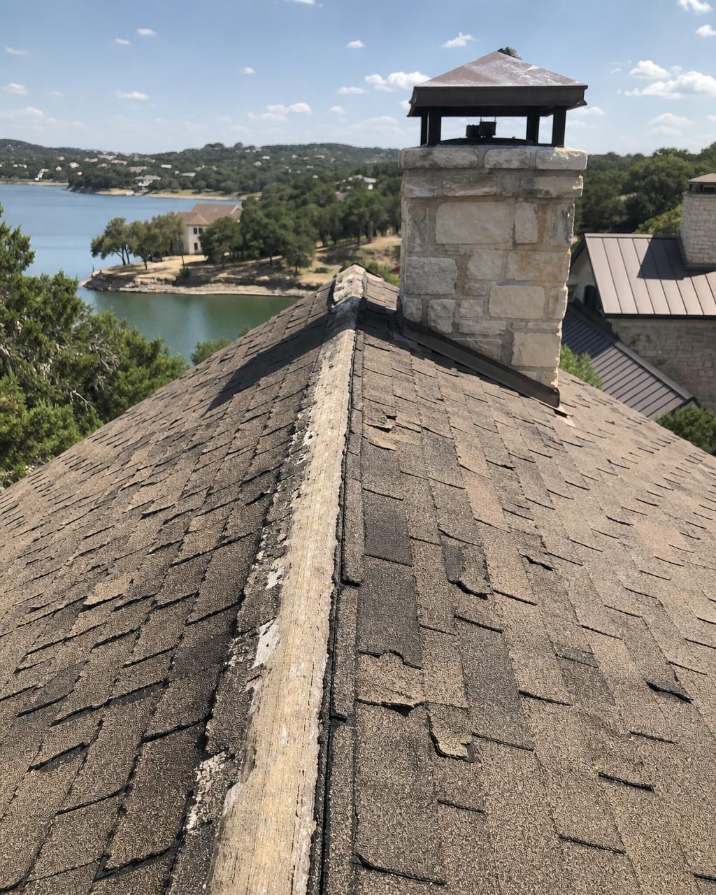 Sun blistered shingles and worn ridge cap on a Granbury, TX home